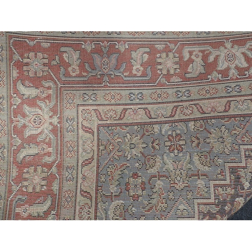 734 - A modern red ground Carpet with blue central medallion amongst floral design within multiple borders... 