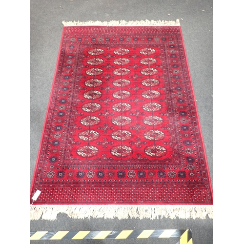 736 - A red ground Persian Rug with three rows of medallions within tramline borders 6ft 10in L x 4ft 8in ... 