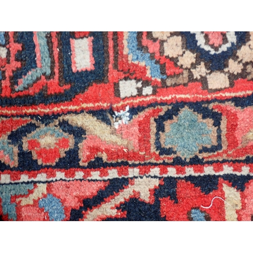 77 - A Persian red ground woollen Carpet with large central lotus flower design amongst stylised flowers ... 