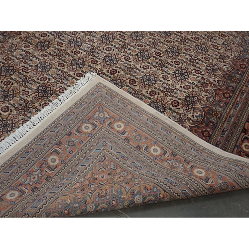 78 - A modern Indo Chahkari Carpet with stylised floral design on cream oval ground within red and blue m... 