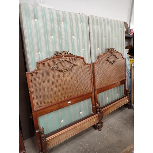 688 - A pair of French walnut framed single Beds with cane headboards and floral wreath decoration 3ft 3in... 