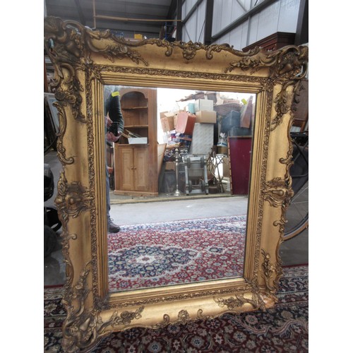 763 - A gilt framed Wall Mirror with elaborate scrolled and floral frame, A/F, 3ft 7in  x 2ft 11in