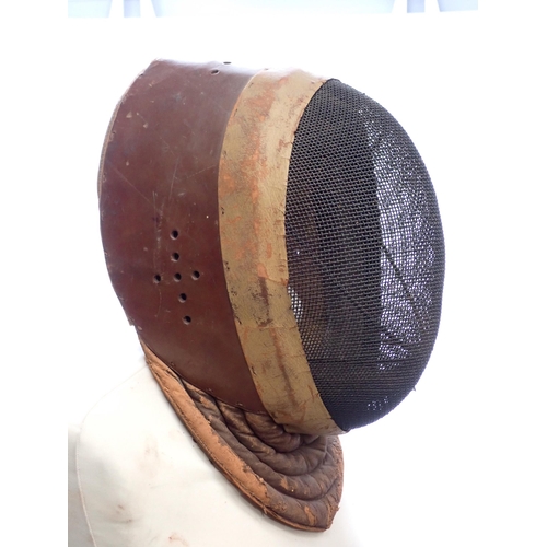 1411 - An early 20th Century Wilkinson Sword Fencing Mask with wire gauze face cover and leather ear guards... 