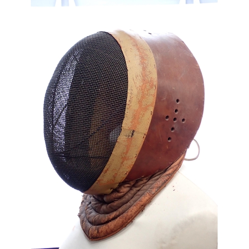 1411 - An early 20th Century Wilkinson Sword Fencing Mask with wire gauze face cover and leather ear guards... 