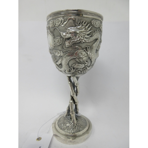 112 - A fine quality Chinese silver Goblet finely decorated dragon amongst clouds on three simulated bambo... 