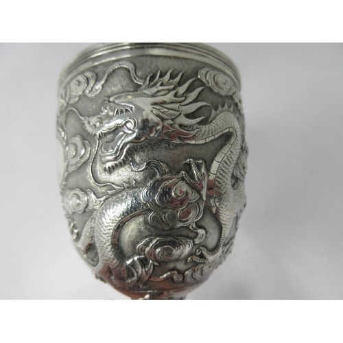 112 - A fine quality Chinese silver Goblet finely decorated dragon amongst clouds on three simulated bambo... 