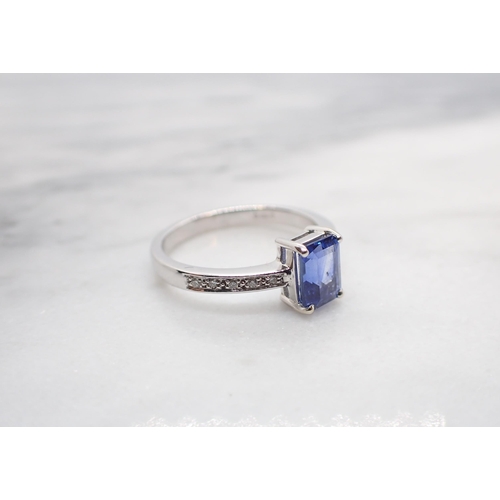 159 - A Sapphire and Diamond Ring corner claw-set step-cut sapphire, 1.53cts, between pavé-set brilliant-c... 