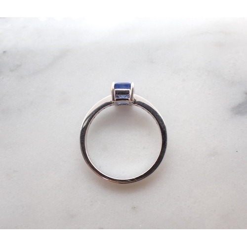 159 - A Sapphire and Diamond Ring corner claw-set step-cut sapphire, 1.53cts, between pavé-set brilliant-c... 