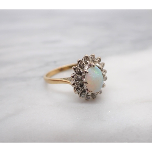 167 - An Opal and Diamond Cluster Ring claw-set oval opal cabochon within a frame of eight-cut diamonds, s... 