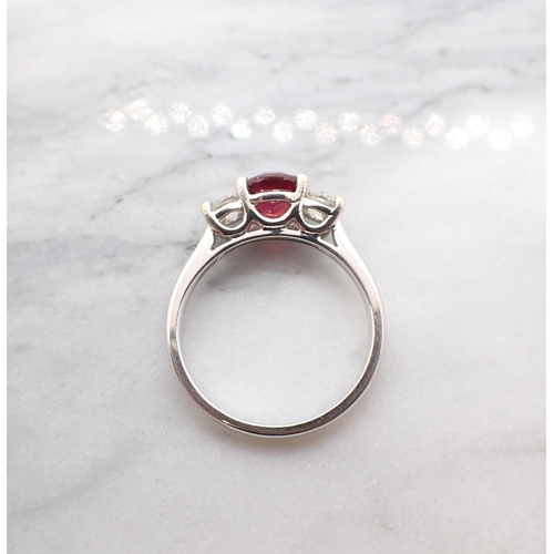 187 - A Ruby and Diamond three stone Ring claw-set round ruby, 1ct, between two brilliant-cut diamonds in ... 