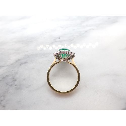 193 - An Emerald and Diamond Cluster Ring claw-set oval-cut emerald, 2.78cts, within a frame of fourteen b... 