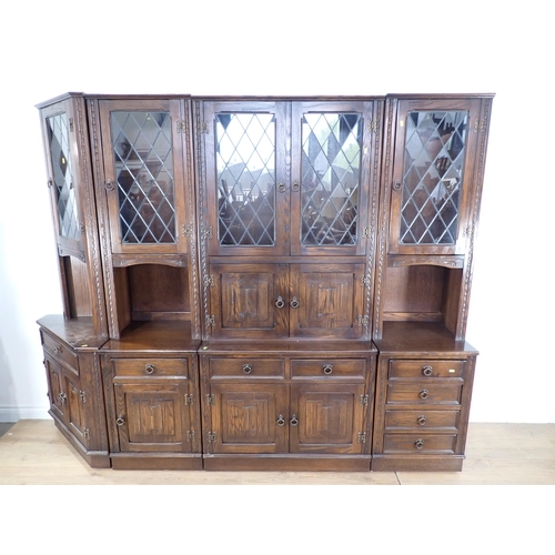 25 - A large section oak Lounge Unit with glazed upper doors and linen fold panels to the lower doors, 6f... 