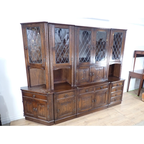 25 - A large section oak Lounge Unit with glazed upper doors and linen fold panels to the lower doors, 6f... 