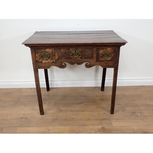 34 - A Georgian oak Lowboy fitted three frieze drawers above a shaped frieze on chamfered squared support... 