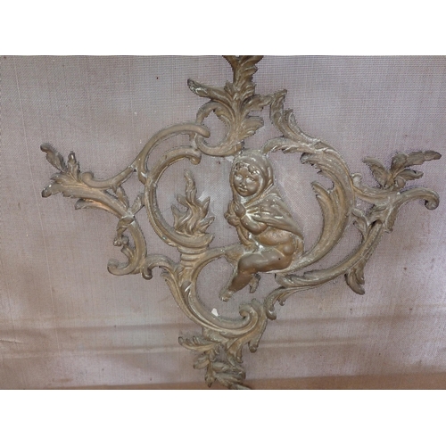 35 - A brass Fire Screen decorated scrolls and a cherub, 2ft 4in H and a pair of brass Fire Dogs