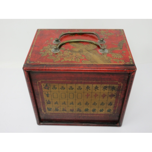 49 - A Mah Jong Set in red lacquered case with slide-up front revealing four drawers, 8in