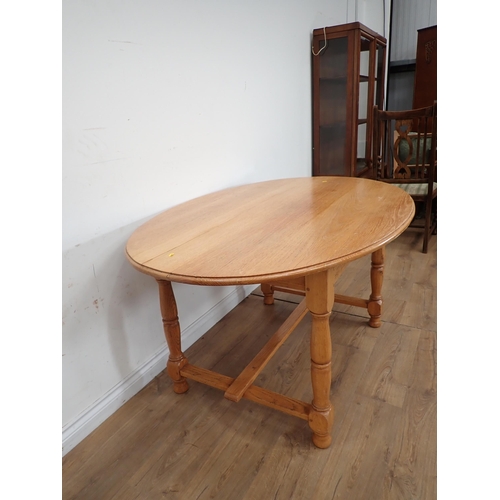 495 - A modern oval oak Dining Table on turned supports with H-stretcher 5ft W x 2ft 6in H