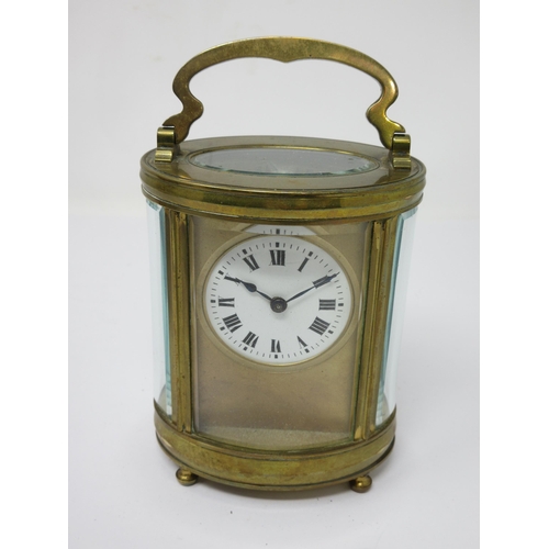 93 - A brass cased oval Carriage Clock with white enamel circular dial, cylinder escapement, 6in, in orig... 