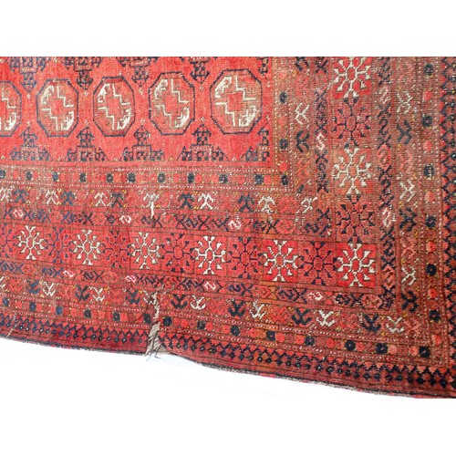 353 - A red ground Persian Rug with three roes of medallions with wide border (tear to side) 6ft 3in L x 4... 