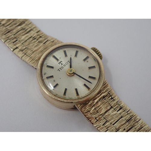 156 - A lady's Tissot manual Wristwatch the champagne dial with hourly baton markers on integral 9ct gold ... 