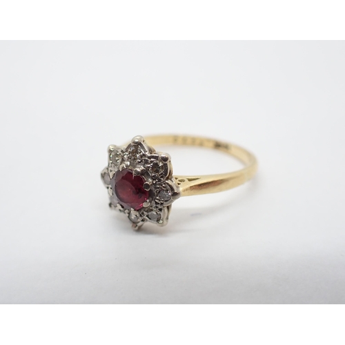 172 - A Ruby and Diamond Cluster Ring claw-set round ruby within a frame of eight brilliant-cut diamonds, ... 