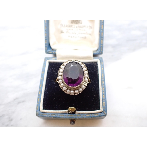 176 - A Cluster Ring set oval purple stone within frame of seed pearls, stamped 9ct, ring size O, lacks on... 