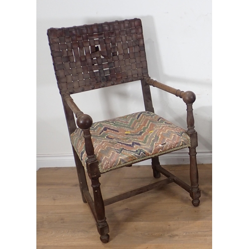 265 - An Arts and Crafts oak Elbow Chair with leather strapwork back and seat