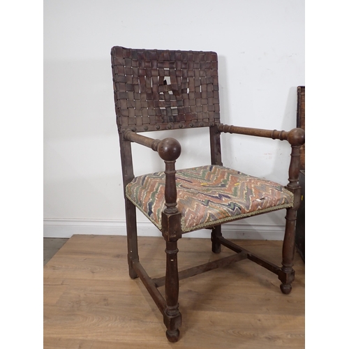 265 - An Arts and Crafts oak Elbow Chair with leather strapwork back and seat