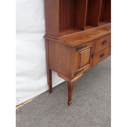 626 - An Arts and Crafts oak Dresser and Rack fitted pair of cupboard doors and two drawers mounted on squ... 