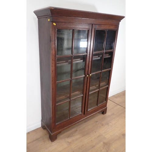 629 - An oak Bookcase fitted pair of glazed doors enclosing shelves on bracket feet 5ft 3in H x 3ft 11in W