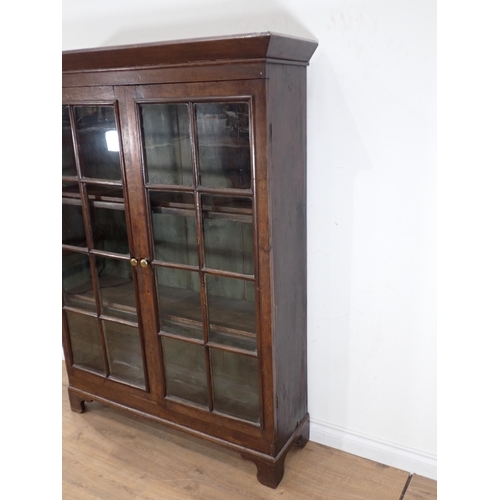 629 - An oak Bookcase fitted pair of glazed doors enclosing shelves on bracket feet 5ft 3in H x 3ft 11in W