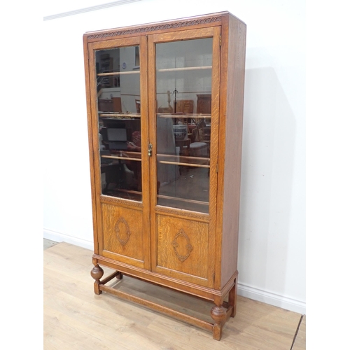 690 - An oak and glazed two door Bookcase with adjustable shelves 6ft 4in H x 3ft 5in W