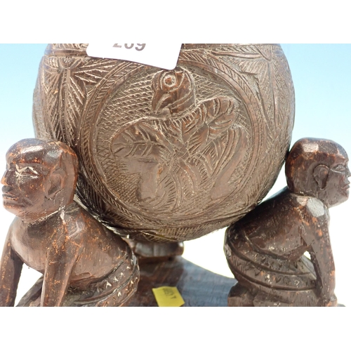 269 - An antique carved Coconut Shell with lid resting upon three kneeling African tribal figures 8in