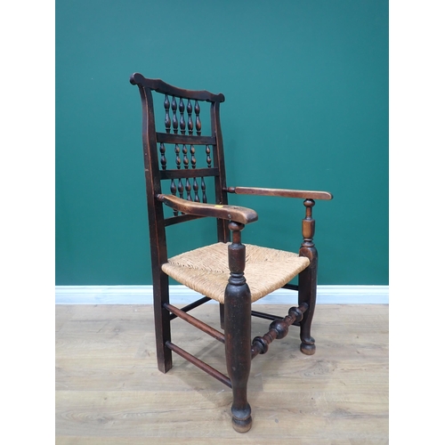 600 - A 19th Century North Country spindle back Elbow Chair with rush seat mounted on heavy turned support... 