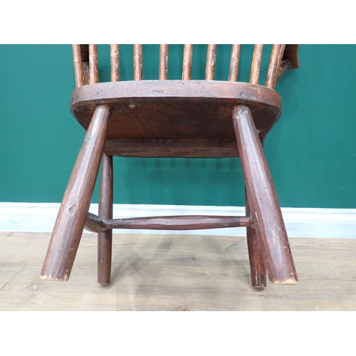 638 - A primitive 19th Century elm seated Windsor Elbow Chair with turned supports and stretchers and a 19... 