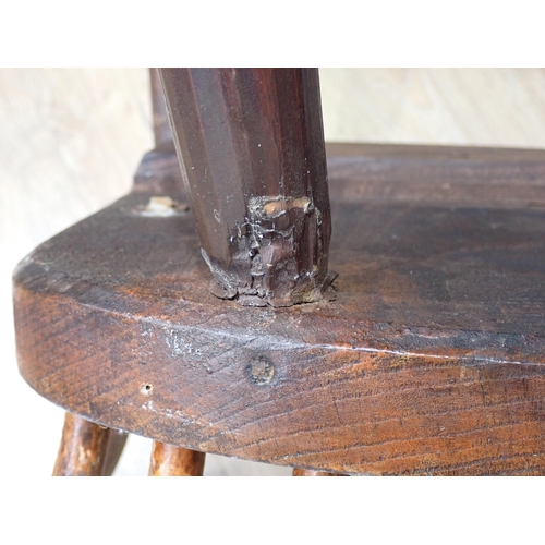 638 - A primitive 19th Century elm seated Windsor Elbow Chair with turned supports and stretchers and a 19... 