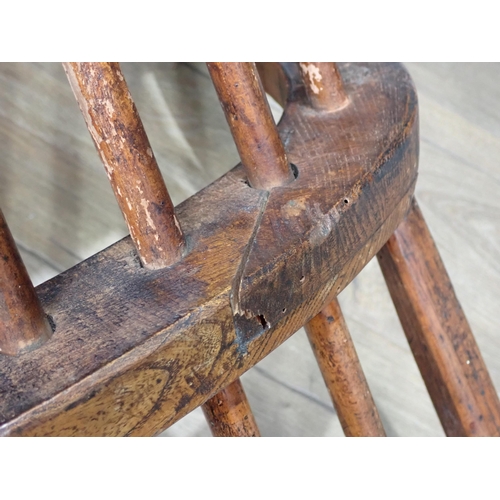 638 - A primitive 19th Century elm seated Windsor Elbow Chair with turned supports and stretchers and a 19... 