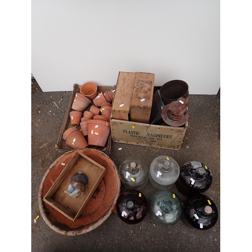 724 - A quantity of terracotta Plant Pots, a large terracotta Bowl, six demijohns a Funnel, a Paraffin Lam... 