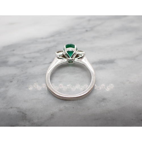 63 - An Emerald and Diamond three stone Ring claw-set oval-cut emerald between two brilliant-cut diamonds... 