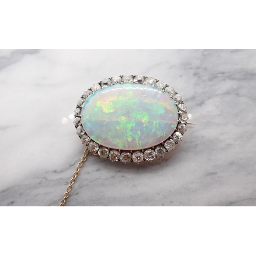 66 - An Opal and Diamond Brooch claw-set oval opal, approx 32mm x 22m within frame of old-cut diamonds, e... 