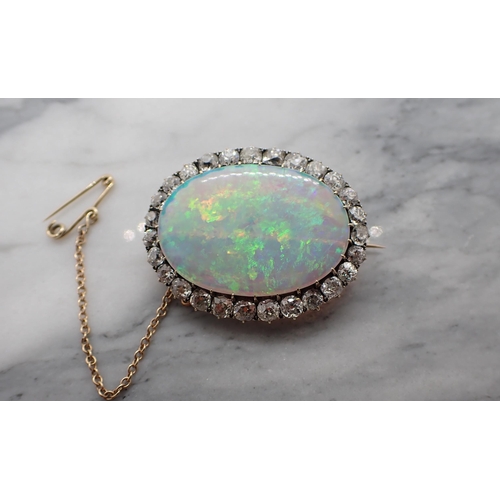 66 - An Opal and Diamond Brooch claw-set oval opal, approx 32mm x 22m within frame of old-cut diamonds, e... 