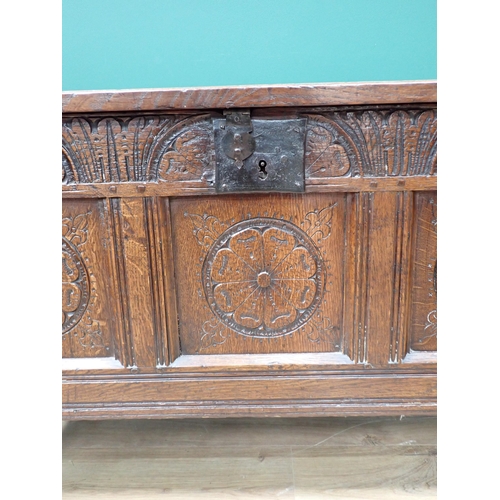 754 - A small 18th Century oak Coffer with panelled top above a rose and lunette panelled carved front