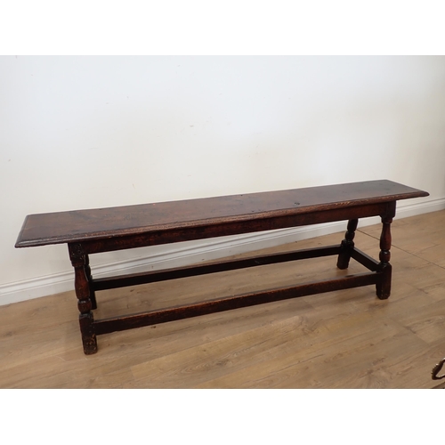 760 - A long joined oak Refectory Bench in the 17th Century style with moulded top mounted upon turned sup... 