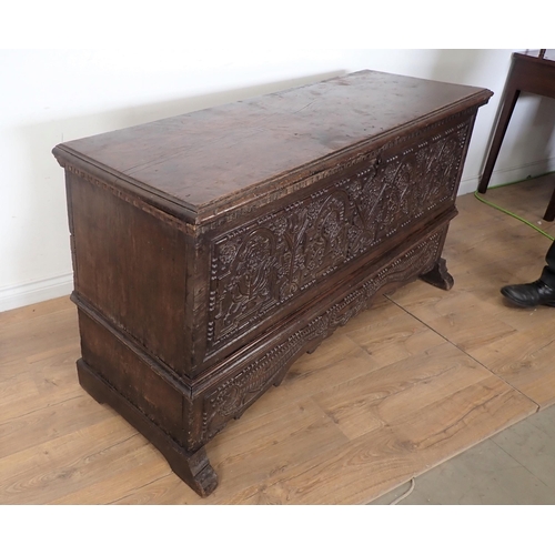 761 - A 17th Century and later oak plank Chest with plain moulded lid above profusely carved front with fo... 