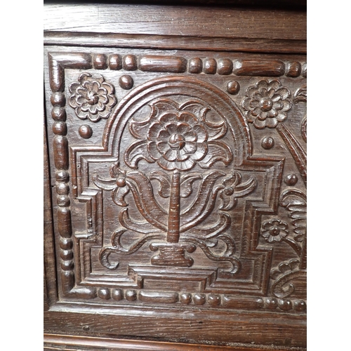 761 - A 17th Century and later oak plank Chest with plain moulded lid above profusely carved front with fo... 