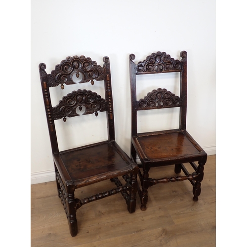 762 - Two 17th Century and later oak Derbyshire Chairs both with mask and scroll carved double back rails