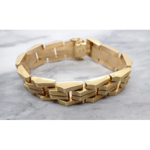 85 - An 18ct gold Bracelet formed from textured, rectangular, angled links, in the style of Kutchinsky, a... 