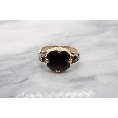 96 - A Georgian Ring close-set cushion shaped red stone between two rose-cut diamonds  and foliate should... 