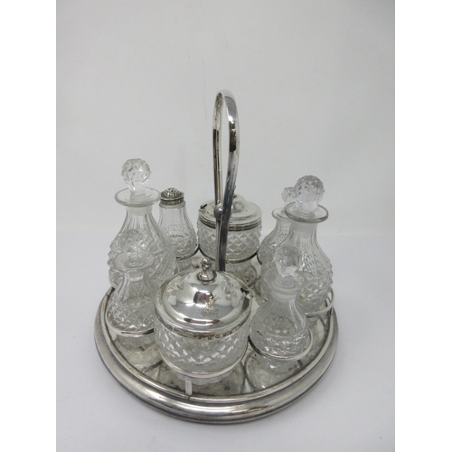 89 - A plated circular Cruet Stand with central handle fitted eight cut glass bottles and jars, two with ... 