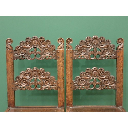 336 - A pair of Charles II style oak Derbyshire with arched scroll, mask and trefoil carved double back ra... 